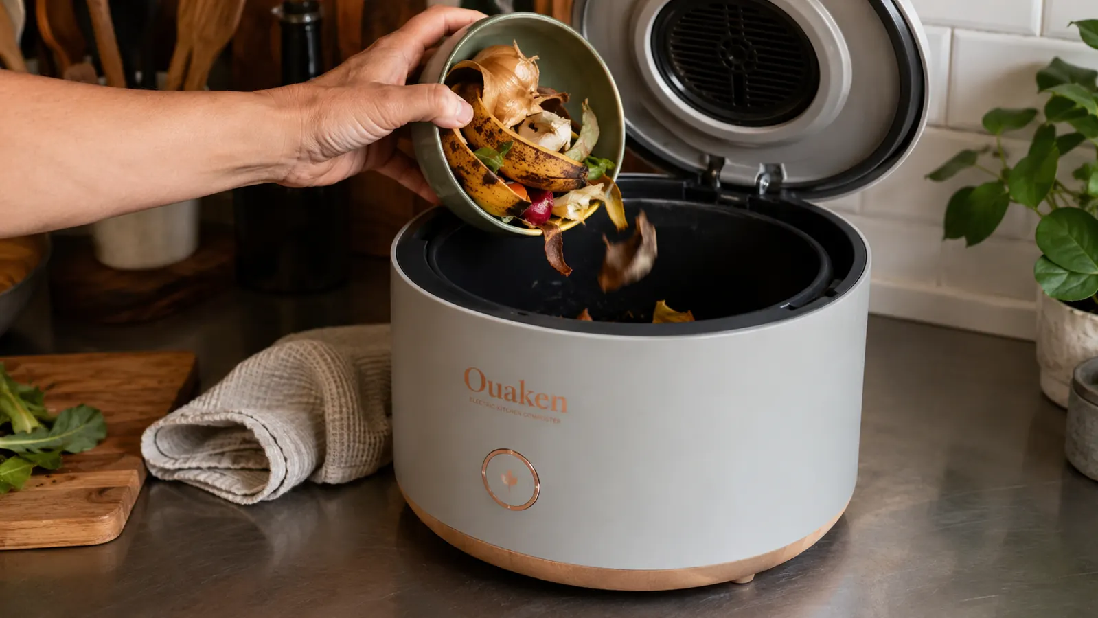 Hand scraping vegetable scraps and coffee grounds into the Ouaken composter's inner bucket
