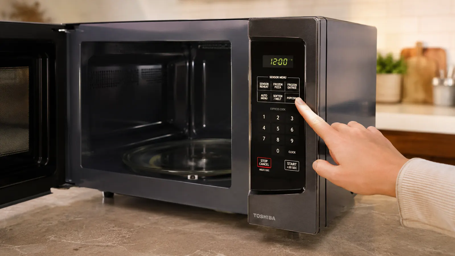 Hand pressing the auto menu button on the Toshiba microwave's control panel